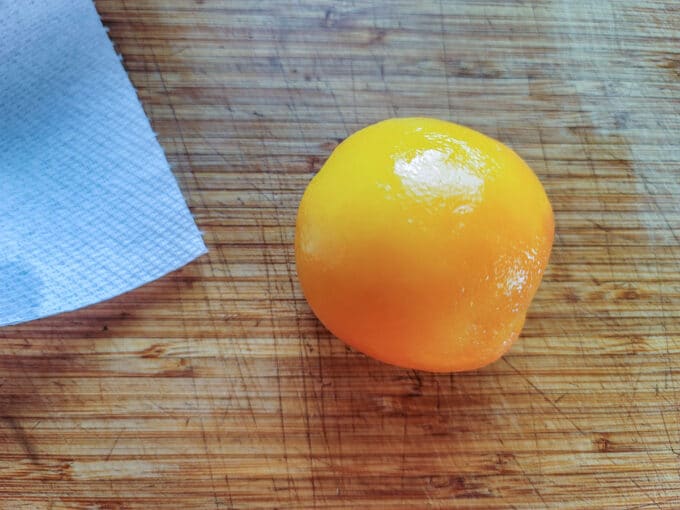 Peeled peach on cutting board.