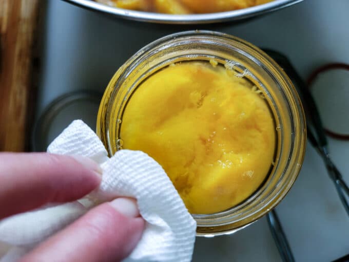 Wiping rim on jar.