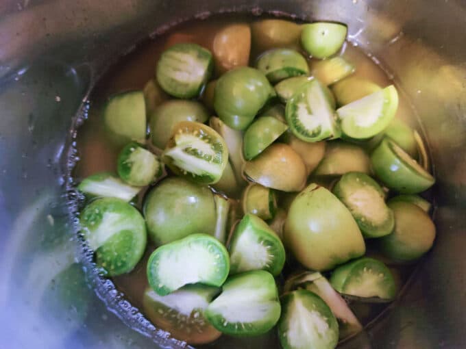 Halved tomatoes in pot .