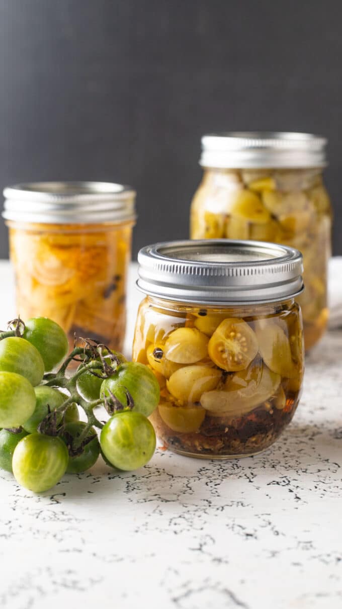 Half pint jar with halved green cherry tomatoes.