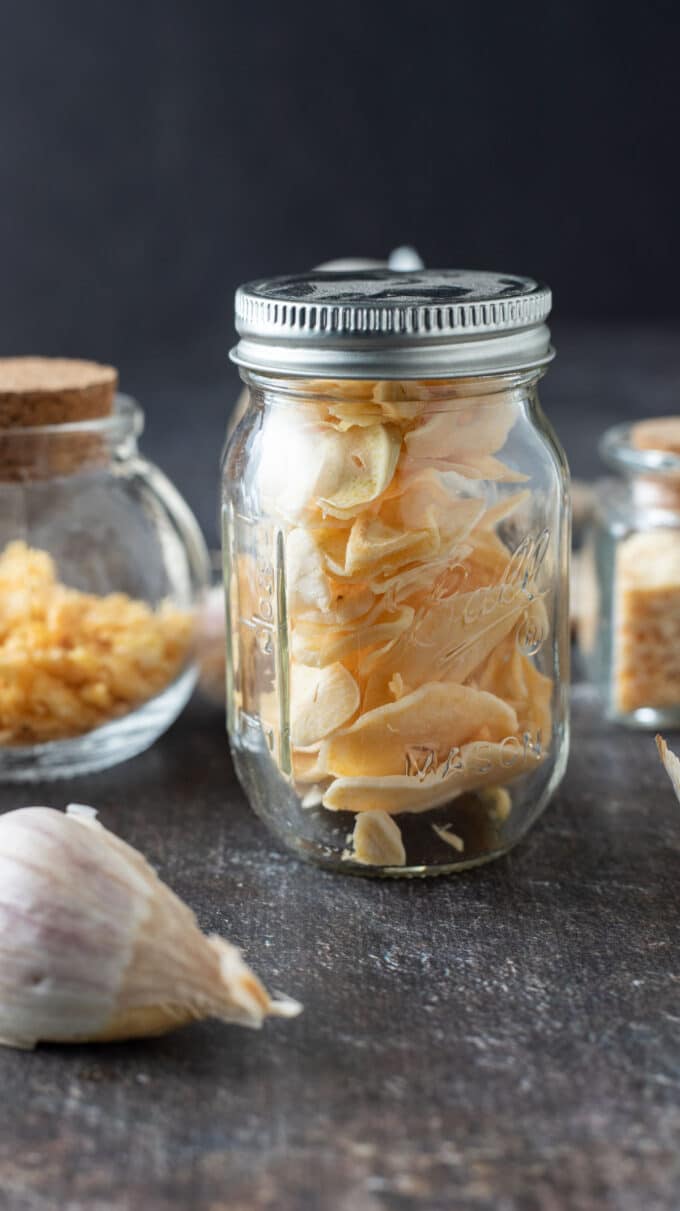 Dried garlic slices in small glass jar.