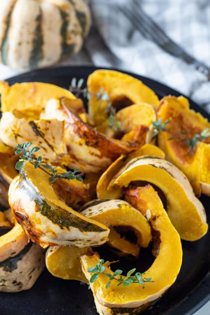 Sliced squash on black plate.