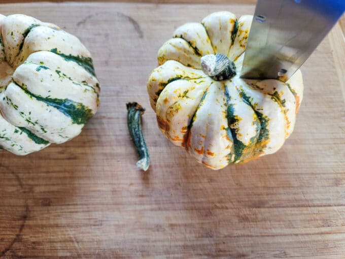 Chef's knife making initial cut into the vegetable.