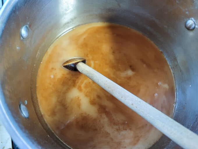 Stirring pot with a wooden spoon.