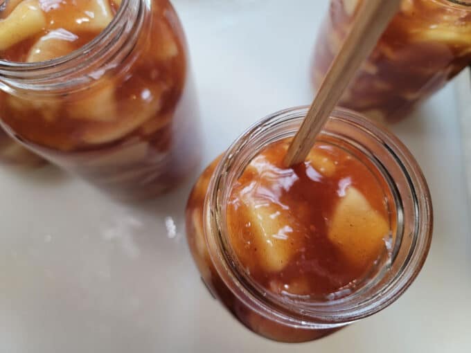 Chopstick removing air bubbles in jar.