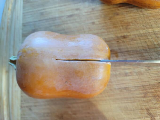 Knife cutting through squash.