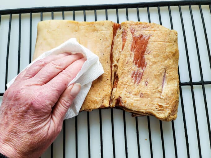 Drying off pork belly with paper towel.