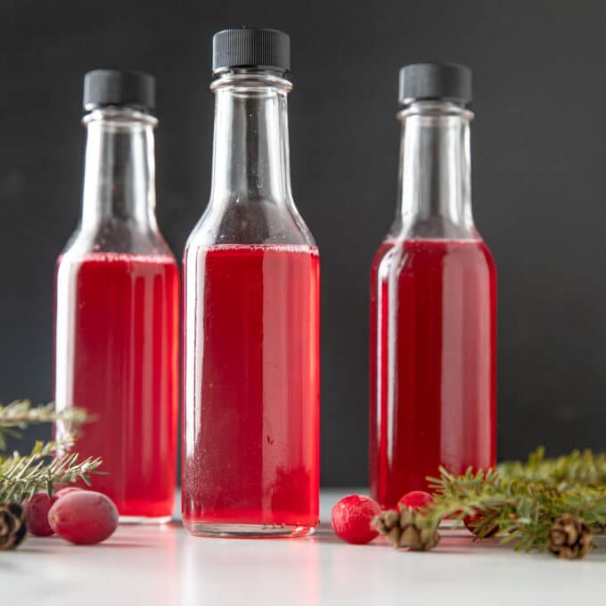 Three small bottles of cranberry vinegar.
