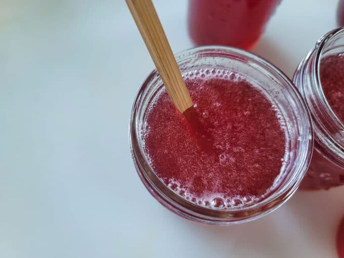 Dogwood Jelly in jars with bubble remover removing bubbles.