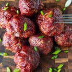 Pile of smoked meatballs on wooden board.