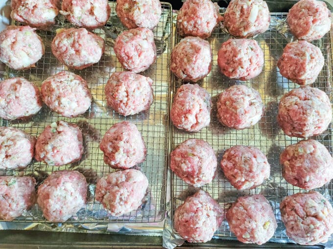 Meatballs lined up on racks ready to go into smoker.
