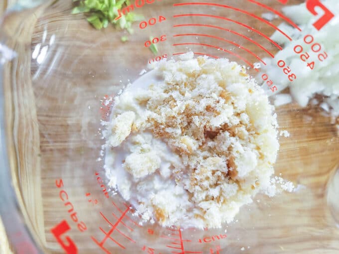 Bread crumbs added to milk in measuring cup.