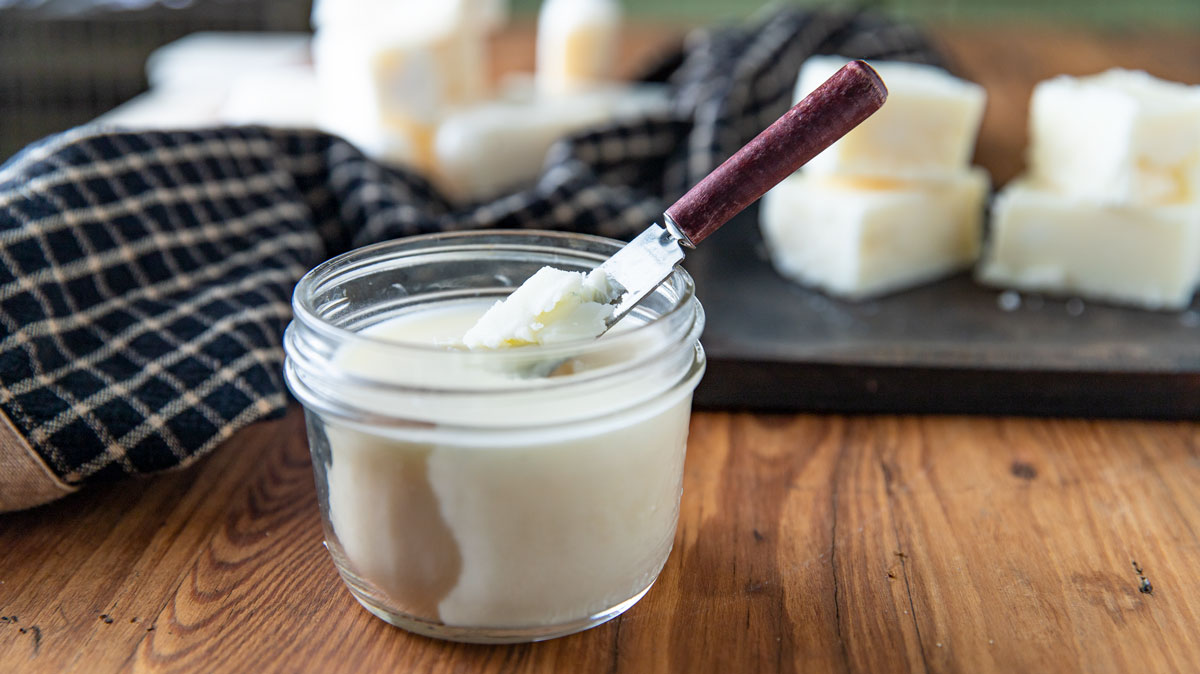 Jar of beef tallow with a small spreading knife.