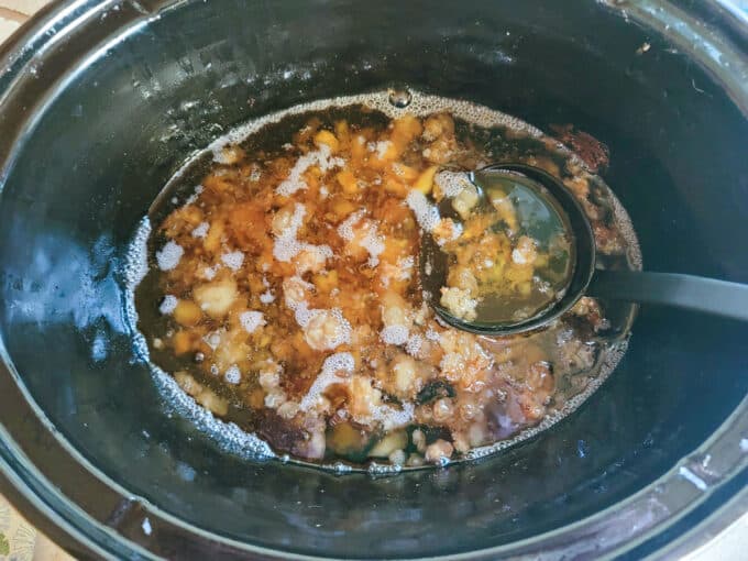 Ladling fat into the strainer.