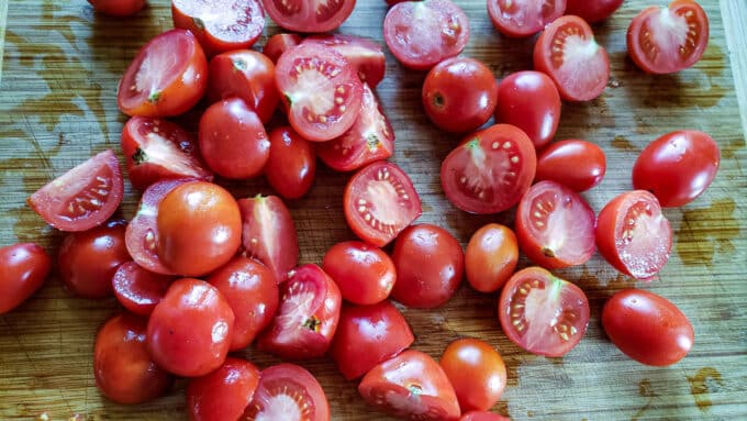 Quartered tomatoes on a cutting board.