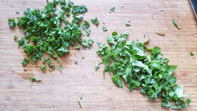 Chopped fresh herbs on a board.