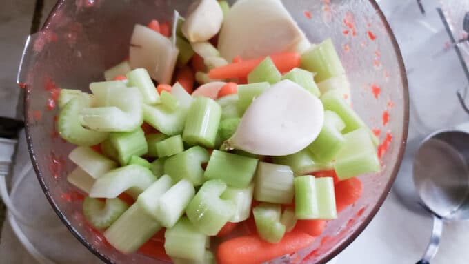 Vegetables added to food processor bowl.