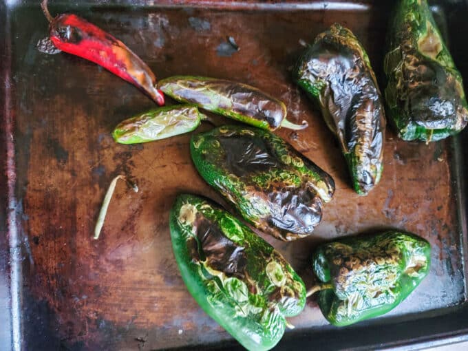 Charred peppers on baking sheet.