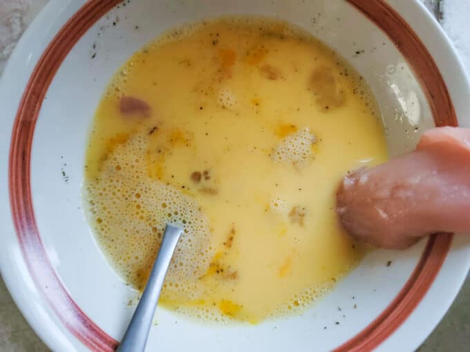 Dipping rabbit into egg wash.