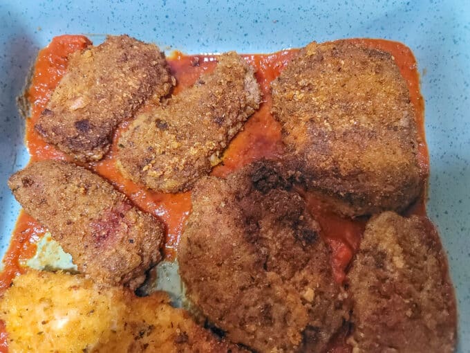Breaded, fried loins it a baking pan with sauce.
