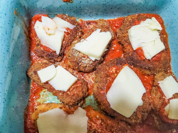Mozzarella topped venison in pan.