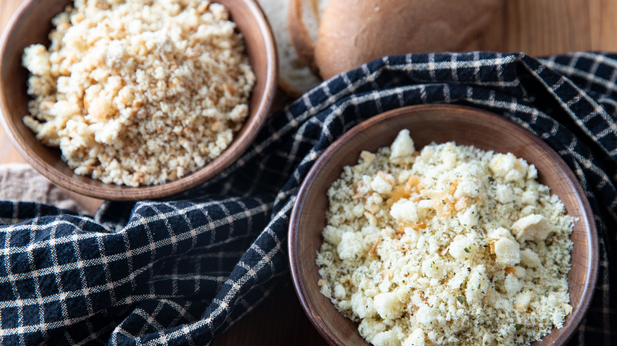 Bowls of dried bread crumbs with fresh bread.