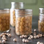 Jars of canned chickpeas on black board.