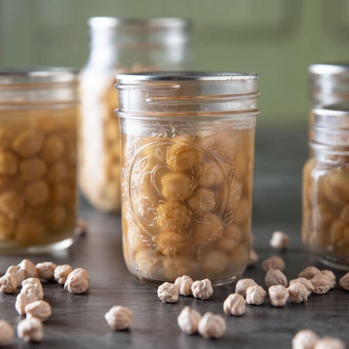 Jars of canned chickpeas on black board.