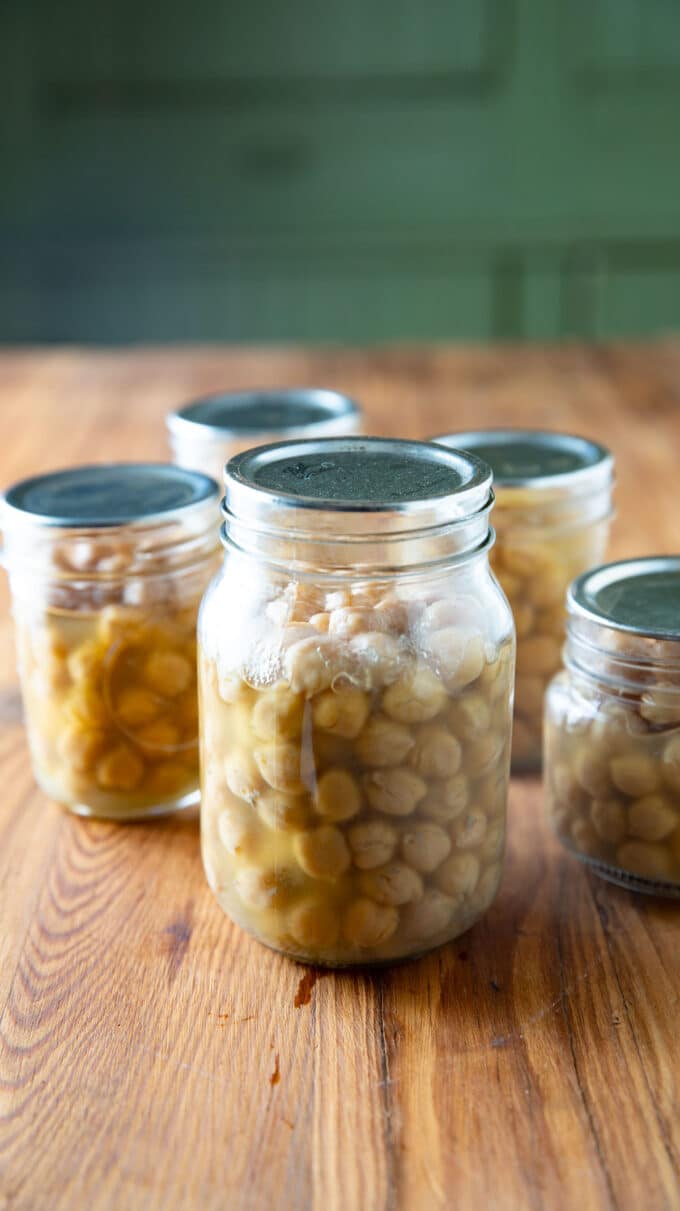 Jars of garbanzos on a barnwood board.