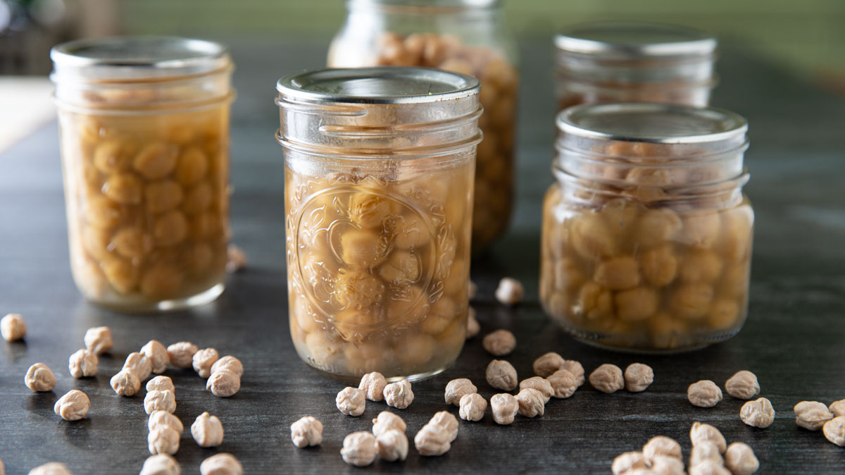 Jars of canned chickpeas on a black background.