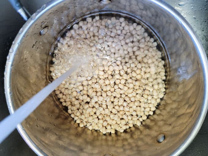 Adding water to beans in a large pot.