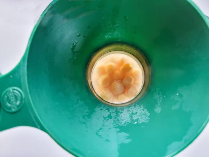 Filling jars using a canning funnel.