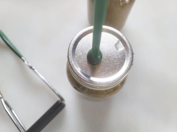 Jar lifter adding lid to jar.