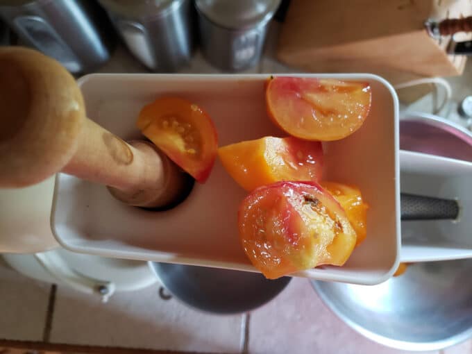 Feeding tomatoes into juicer.