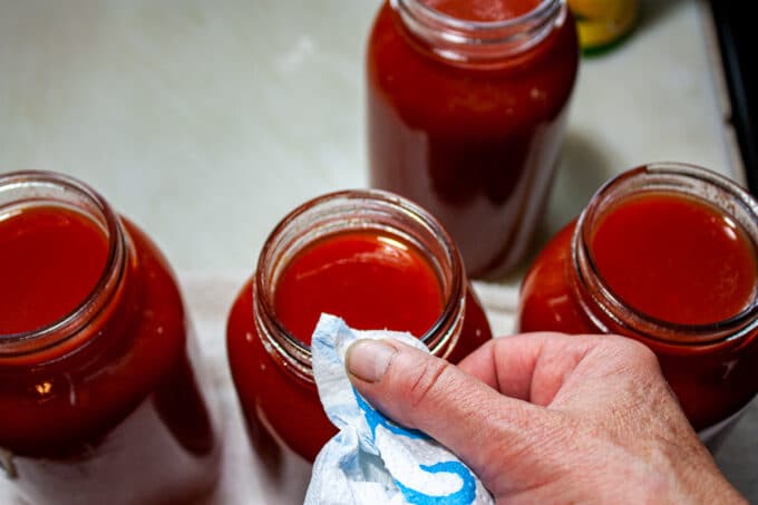 Wiping the rims of the jars.