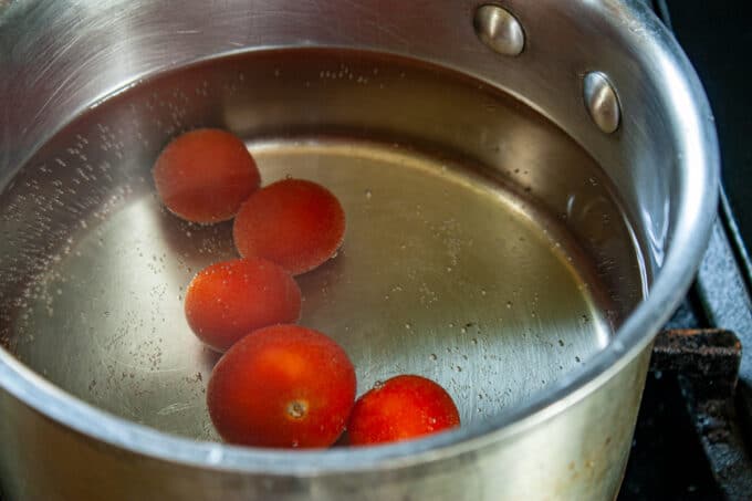Tomatoes added to a pot of boiling water.