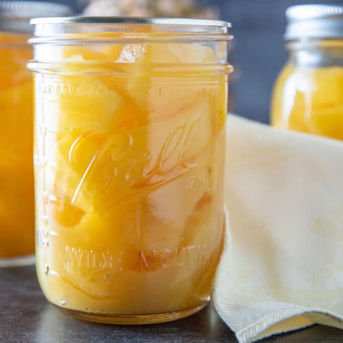 Jars of colorful canned pineapple.