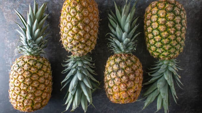 Whole pineapples on a dark background.