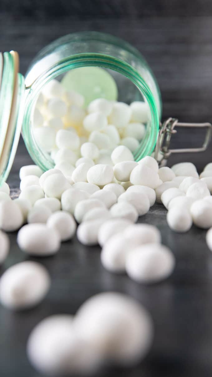 Marshmallows spilling from a green storage jar.