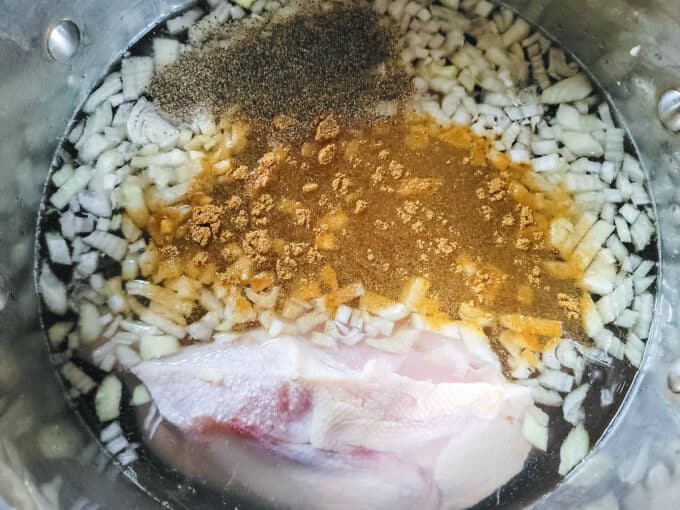 Chicken and spices added to large pot and covered with water.