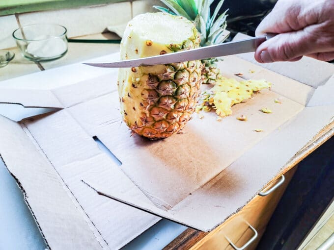 Cutting the skin from the fruit.