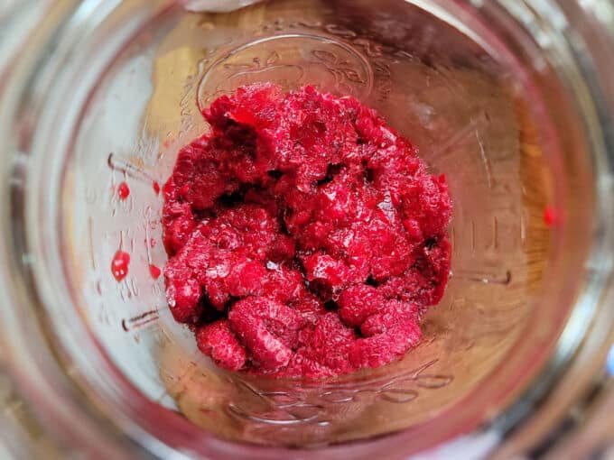 Raspberries added to a quart jar.