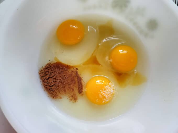 Eggs, cinnamon and vanillas added to a bowl.