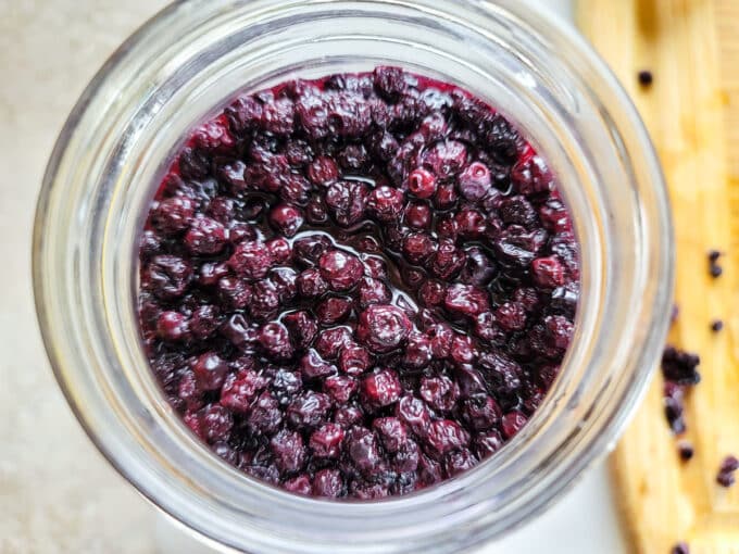 Vinegar added to berries in jar.