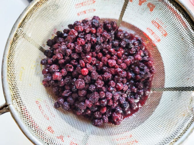 Straining vinegar with a fine-meshed strainer.