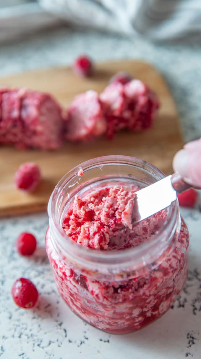 Scooping the cranberry butter out of the jar with a butter knife.