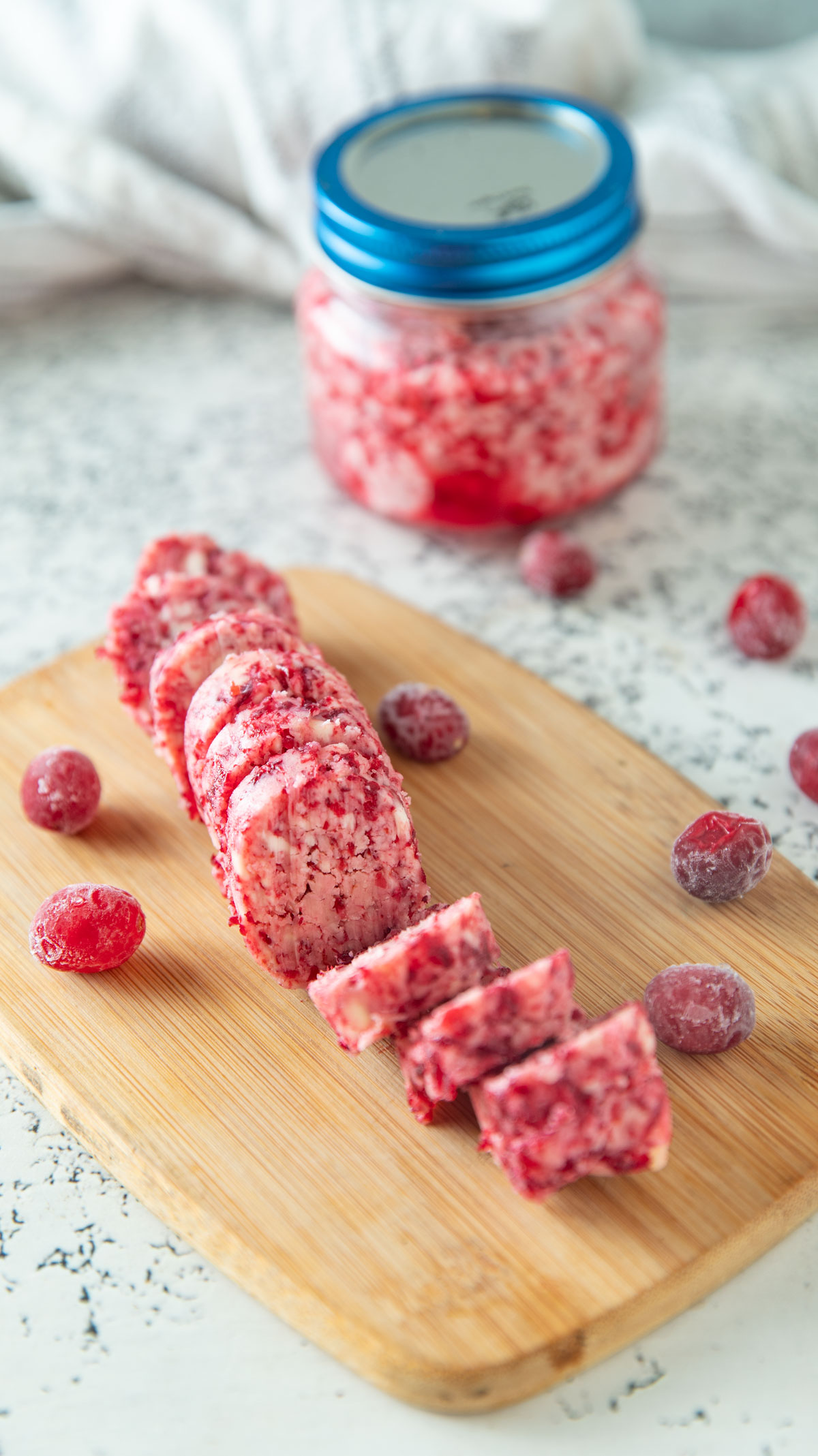 Slices of cranberry butter on a wooden board.