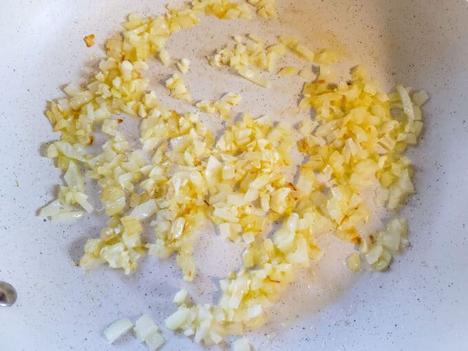 Garlic and onion sautéing in a large skillet.