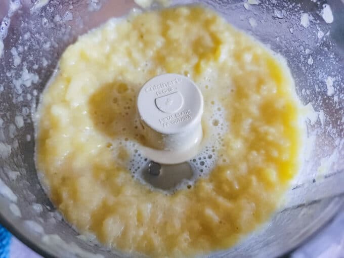 Processed pineapple in a food processor bowl.