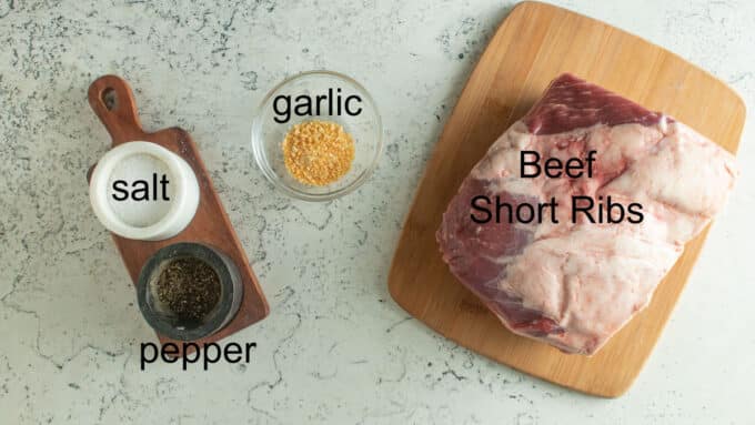 Ingredients for smoked beef short ribs. Salt, pepper, garlic and short ribs.
